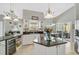 Open kitchen with white cabinets, granite countertops, and stainless steel appliances at 4733 Spring Meadow Ln, Sarasota, FL 34233