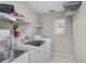 Practical laundry room features a utility sink, washer, dryer, and ample shelving for storage at 4733 Spring Meadow Ln, Sarasota, FL 34233