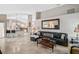 Open-concept living room showcases a kitchen with a breakfast bar, travertine floors, and natural light at 4733 Spring Meadow Ln, Sarasota, FL 34233