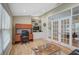 Home office with a built-in desk and shelving, glass panel door, and light colored wood flooring at 4733 Spring Meadow Ln, Sarasota, FL 34233