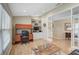 Home office with a built-in desk and shelving, glass panel door, and light colored wood flooring at 4733 Spring Meadow Ln, Sarasota, FL 34233