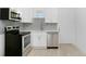 A stylish kitchen with stainless steel appliances, white cabinets and a gray tiled backsplash at 4796 Duncan Rd, Punta Gorda, FL 33982