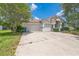 Exterior shot of home with lush trees, and a large driveway leading to the two-car garage at 4915 Bookelia Cir, Bradenton, FL 34203