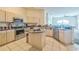 Well-lit kitchen with stainless steel appliances, island, and light-colored cabinets at 4915 Bookelia Cir, Bradenton, FL 34203