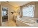 Primary bathroom featuring a garden tub and patterned window treatment at 4915 Bookelia Cir, Bradenton, FL 34203