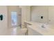 Bright bathroom featuring white tiled floors, large mirror and combined shower and door to the patio at 4957 Sabal Lake Cir, Sarasota, FL 34238