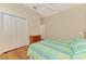 Bedroom features wood floors, fan, closet and chest of drawers at 4957 Sabal Lake Cir, Sarasota, FL 34238