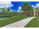 Exterior of the community clubhouse showcasing a lake view, verdant landscaping and ample green space at 4957 Sabal Lake Cir, Sarasota, FL 34238