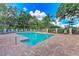 View of the community pool and lounge area, surrounded by a fence and lush landscaping at 4957 Sabal Lake Cir, Sarasota, FL 34238