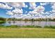 Scenic lake view with lush greenery and a clear blue sky filled with fluffy white clouds at 4957 Sabal Lake Cir, Sarasota, FL 34238