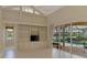 Living room featuring a built-in shelving unit, tiled floors, and a backyard pool view at 4957 Sabal Lake Cir, Sarasota, FL 34238