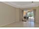 Spacious living room with tile flooring and sliding glass doors leading to an outdoor dining area at 4957 Sabal Lake Cir, Sarasota, FL 34238
