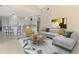 Open living room with vaulted ceiling, modern decor, and adjacent kitchen with breakfast bar at 4957 Sabal Lake Cir, Sarasota, FL 34238