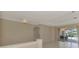 Bright, spacious living room with tiled floor and sliding glass doors to outdoor seating area and pool at 4957 Sabal Lake Cir, Sarasota, FL 34238
