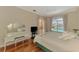 Bright main bedroom boasts wood floors and a large window view of pool and lake at 4957 Sabal Lake Cir, Sarasota, FL 34238