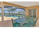 Covered patio featuring an outdoor dining area, overlooking pool, lake and lanai views at 4957 Sabal Lake Cir, Sarasota, FL 34238