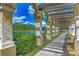 Sidewalk path showing lush tropical landscaping, a lake view and trellised shade structure at 4957 Sabal Lake Cir, Sarasota, FL 34238