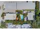 Aerial view of a property with a refreshing pool, vibrant umbrellas, and tropical landscaping at 509 Pine Ave # A, Anna Maria, FL 34216