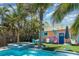 Backyard area featuring a pool, lush tropical landscaping, colorful seating, and a relaxing lounge area at 509 Pine Ave # A, Anna Maria, FL 34216