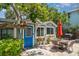 Backyard patio featuring lush greenery, an umbrella, and a dining table with four chairs at 509 Pine Ave # A, Anna Maria, FL 34216