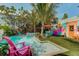 Inviting pool area with lush tropical landscaping, colorful seating, and a relaxing lounge area at 509 Pine Ave # A, Anna Maria, FL 34216