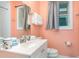 Charming bathroom with vintage-style fixtures, complemented by a sink and soft coral walls at 509 Pine Ave # A, Anna Maria, FL 34216
