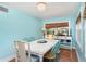 Bright dining room featuring a rustic white table set, bead chandelier, and tranquil blue walls at 509 Pine Ave # A, Anna Maria, FL 34216