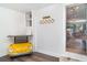 A hallway with a quirky yellow car-shaped table and glimpse into a bright, inviting living space at 509 Pine Ave # A, Anna Maria, FL 34216