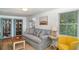 Cozy living room featuring a comfortable sofa, bookshelves, and a bright yellow accent chair at 509 Pine Ave # A, Anna Maria, FL 34216