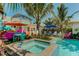 Inviting backyard features a sparkling pool, hot tub, colorful umbrellas, and lush greenery at 509 Pine Ave # A, Anna Maria, FL 34216
