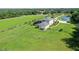 Aerial view showcasing a home with a screened-in pool, green lawns, and lush landscaping in a peaceful setting at 520 Rye Ne Rd, Bradenton, FL 34212