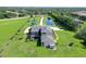 Aerial view showcasing a home with a screened-in pool, green lawns, and lush landscaping in a peaceful setting at 520 Rye Ne Rd, Bradenton, FL 34212