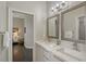Modern bathroom features double vanity with framed mirrors and a view into the bedroom at 520 Rye Ne Rd, Bradenton, FL 34212
