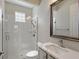 Bright bathroom featuring a glass-enclosed shower, white tiles, and vanity with a modern faucet at 520 Rye Ne Rd, Bradenton, FL 34212