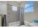 Bathroom showcasing a shower and tub with grey tile and a window for natural light at 520 Rye Ne Rd, Bradenton, FL 34212