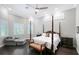 Bedroom features dark floors, shutters, a four poster bed and an accent chair at 520 Rye Ne Rd, Bradenton, FL 34212