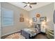 Bedroom showcasing a twin bed, ceiling fan, window, and unique decorative wall hangings at 520 Rye Ne Rd, Bradenton, FL 34212