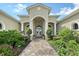 Elegant home exterior with a brick path leading to the front door, complemented by lush, colorful landscaping at 520 Rye Ne Rd, Bradenton, FL 34212