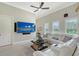 Bright living area with white sectional, ceiling fan, and a wall-mounted television at 520 Rye Ne Rd, Bradenton, FL 34212
