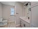 Modern bathroom featuring gray cabinetry, quartz countertop, walk-in shower, and wood-look tile floors at 5523 Secluded Oaks Way, Sarasota, FL 34233
