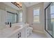 Modern bathroom with white cabinets, black hardware, and a shower with glass door at 5523 Secluded Oaks Way, Sarasota, FL 34233