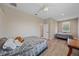Comfortable bedroom with two twin beds, ceiling fan, and neutral walls, ideal for relaxation at 5523 Secluded Oaks Way, Sarasota, FL 34233
