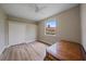 A comfortable bedroom with a ceiling fan, hardwood floors, and a window with a view at 5523 Secluded Oaks Way, Sarasota, FL 34233