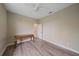 A light bedroom with hard wood floors, a ceiling fan, and an adjacent open door at 5523 Secluded Oaks Way, Sarasota, FL 34233
