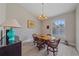 Dining room with wood table, elegant chandelier, and large window at 5523 Secluded Oaks Way, Sarasota, FL 34233