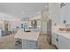 Bright kitchen features stainless steel appliances, an island with counter seating, and white cabinets and tiled backsplash at 5523 Secluded Oaks Way, Sarasota, FL 34233
