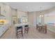 Bright and open kitchen with an island, bar stool seating, stainless steel appliances, a breakfast nook, and tile floors at 5523 Secluded Oaks Way, Sarasota, FL 34233