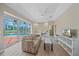 Bright living room featuring wood floors, a ceiling fan and large sliding glass doors to the pool at 5523 Secluded Oaks Way, Sarasota, FL 34233