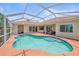Screened-in pool area with a backyard view, offering both privacy and leisure in sunny setting at 5523 Secluded Oaks Way, Sarasota, FL 34233