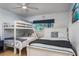 Comfortable bedroom with a bunk bed, a twin bed, and a window for natural light at 5600 Beach Way Dr # 315, Sarasota, FL 34242